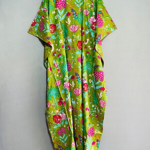 Peut inclure: Une longue kaftan verte &agrave; imprim&eacute; floral avec des fleurs roses, rouges et bleues, des oiseaux et des cerfs. La kaftan a une silhouette ample et fluide et des manches courtes.