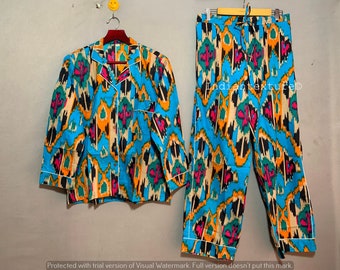 May include: A blue and orange patterned pajama set with a long-sleeved shirt and pants. The shirt has a button-up front and a collar. The pants have an elastic waistband and a drawstring.