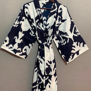 May include: A black and white patterned robe with a tie belt. The robe is made of cotton and has a relaxed fit.