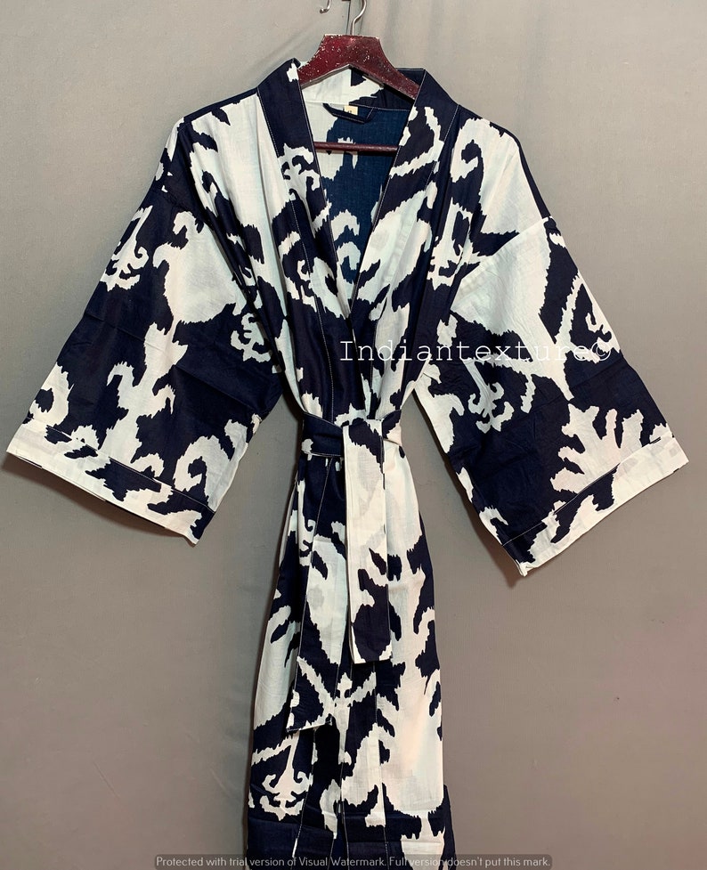 May include: A black and white patterned robe with a tie belt. The robe is made of cotton and has a relaxed fit.