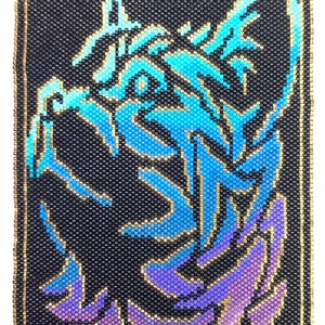 May include: A beaded wall hanging with a black background and a blue and purple gradient image of a cat's head. The image is outlined in gold beads.