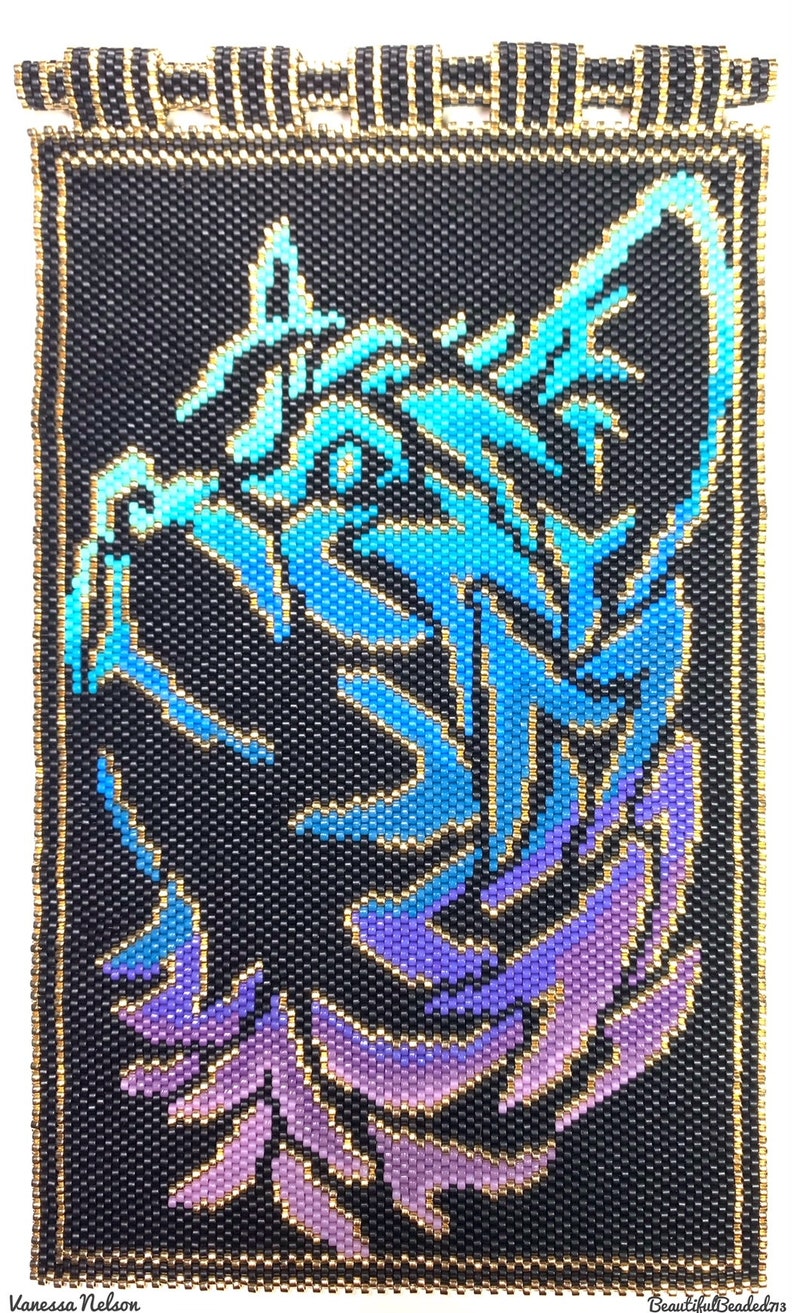 May include: A beaded wall hanging with a black background and a blue and purple gradient image of a cat's head. The image is outlined in gold beads.