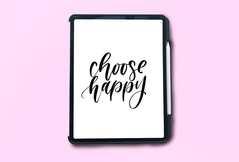 Puede incluir: Una tableta negra con una pantalla blanca que muestra el texto "choose happy" en caligraf&iacute;a negra. La tableta est&aacute; sobre un fondo rosa.