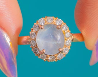 Ring van 14 karaats goud met een lila sterrobijn van 1,85 karaat en een cluster van diamanten.