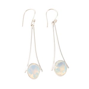 Könnte beinhalten: Ein Paar silberne Ohrringe mit einem weißen Opal-Edelstein an jedem Ohrring.