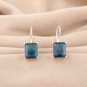 Puede incluir: Un par de pendientes de plata con gotas cuadradas de piedra preciosa azul.