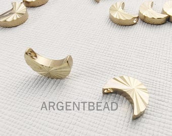 Puede incluir: Hallazgos de joyería dorados en forma de media luna con un diseño texturizado de rayos de sol. Los hallazgos tienen una forma curva y pequeños agujeros para sujetarlos. La palabra "ARGENTBEAD" está impresa.