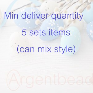 May include: Easter-themed image featuring pastel-colored eggs with floral patterns and speckled designs. The eggs are arranged on a white wooden surface with sprigs of pussy willow and a blue ribbon. Text on the image reads "Min deliver quantity 5 sets items (can mix style)".