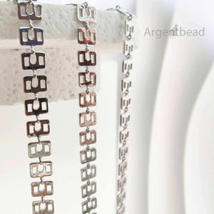 May include: Close-up of three silver-toned metal chains. Each chain features a repeating pattern of rectangular links with a cut-out design. The chains are displayed against a white background, with the text "Argentbead" visible.