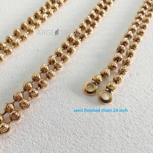 Può includere: Primo piano di una catena semilavorata color oro. La catena è composta da piccole perline rotonde con un design strutturato. La catena è lunga 61 cm. Il testo "semi finished chain 24 inch" è visibile.