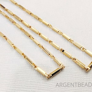 Puede incluir: Tres cadenas de oro con un patrón de eslabones de caja. Las cadenas están superpuestas y todas tienen la misma longitud.
