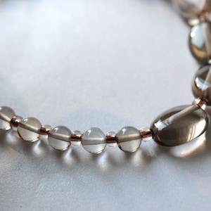 Op de afbeelding: Een ketting gemaakt van heldere en rookkleurige kwarts kralen met roségouden accenten.