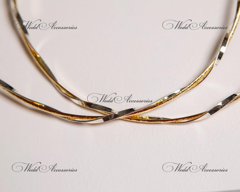 May include: Two intertwined silver and gold rings, a wedding accessory.