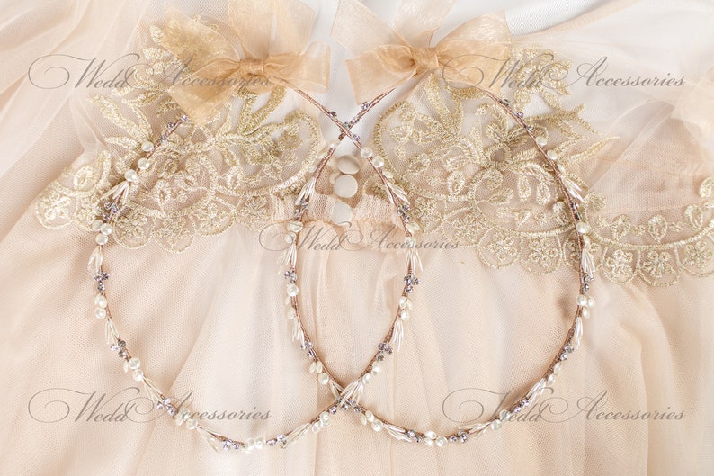 May include: Two delicate wedding headbands with pearl and crystal accents. Each headband features a thin, flexible wire base adorned with small pearls, crystals, and subtle purple beads. The headbands are topped with a sheer, light brown bow.