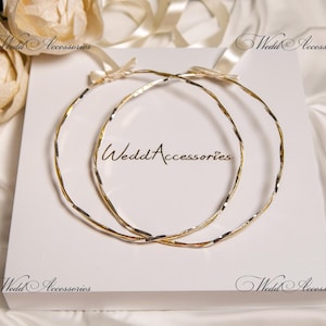 May include: Two gold and silver intertwined wedding rings on a white background. The rings are a traditional symbol of marriage and commitment.