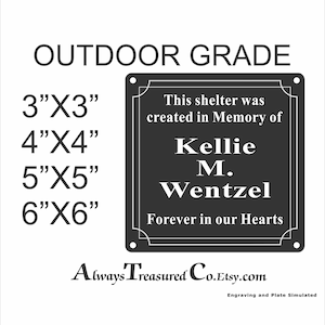 May include: Black metal memorial plaque with white text. The plaque reads "This shelter was created in memory of Kellie M. Wentzel. Forever in our hearts." The plaque is available in sizes 3x3 inches, 4x4 inches, 5x5 inches, and 6x6 inches.