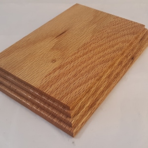 May include: A wooden display stand with a layered design. The stand is made of natural wood with a light brown color and a smooth finish.