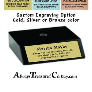 May include: A black trapezoidal base with a gold-colored metal plate featuring black engraved text that reads: Martha Mayho, Thank you for the extra mile that you always go to make our organization a success. Options include gold, silver, or copper finishes.