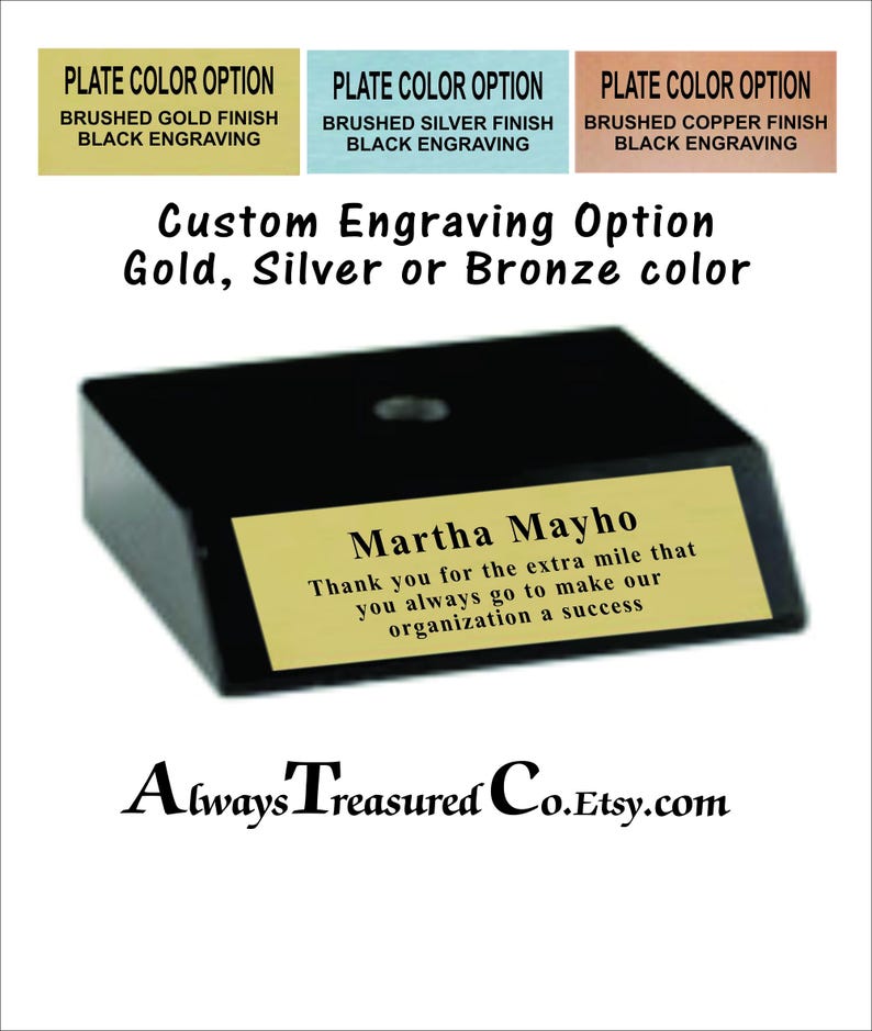 May include: A black trapezoidal base with a gold-colored metal plate featuring black engraved text that reads: Martha Mayho, Thank you for the extra mile that you always go to make our organization a success. Options include gold, silver, or copper finishes.