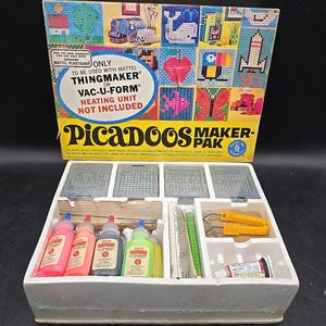May include: A box of PicaDOOS Maker-Pak, a craft kit for making plastic creations. The box shows a variety of colorful designs that can be made with the kit. The box includes a heating unit, not included, to be used with Mattel ThingMaker or Vac-U-Form. The box also includes a variety of colors of Plastigoop.