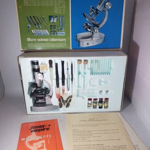 May include: A vintage Jason Empire 750 Power Zoom Microscope Set in a blue and green box. The set includes a microscope, slides, tweezers, and other tools for scientific exploration. The box also includes a booklet with instructions and 12 exciting experiments.