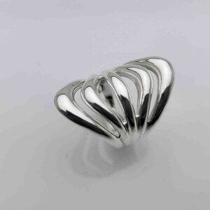 May include: A silver ring with a unique, abstract design. The ring is made of multiple curved bands that are intertwined to create a flowing, organic shape.