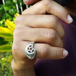 Peut inclure: Une bague en argent avec un motif de croissant de lune comportant une étoile découpée au centre.