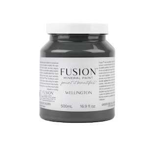 May include: A 16.9 fluid ounce bottle of Fusion Mineral Paint in the color Wellington. The paint is a dark gray color and the bottle has a white label with the Fusion logo and the name of the color.