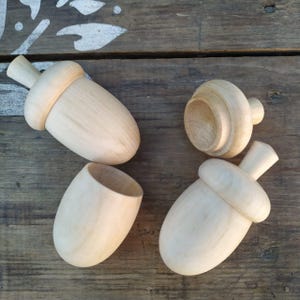 Può includere: Tre scatole di legno non finite a forma di ghianda. Le scatole sono in legno chiaro e hanno una finitura liscia. Le scatole sono aperte e pronte per essere dipinte o decorate.