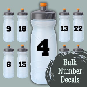 May include: A set of ten clear plastic water bottles with black numbers on them. The numbers are 4, 6, 9, 13, 15, 18, 22. The bottles are arranged in two rows of five. The text "Bulk Number Decals" is written in black on a gray background.