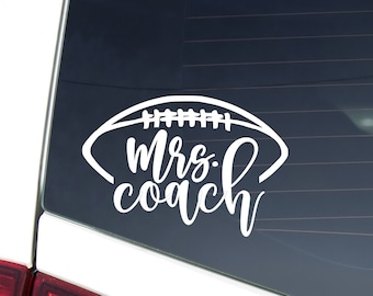 Peut inclure: Autocollant en vinyle blanc avec un motif de ballon de football et le texte "Mrs. Coach" sur une voiture blanche.