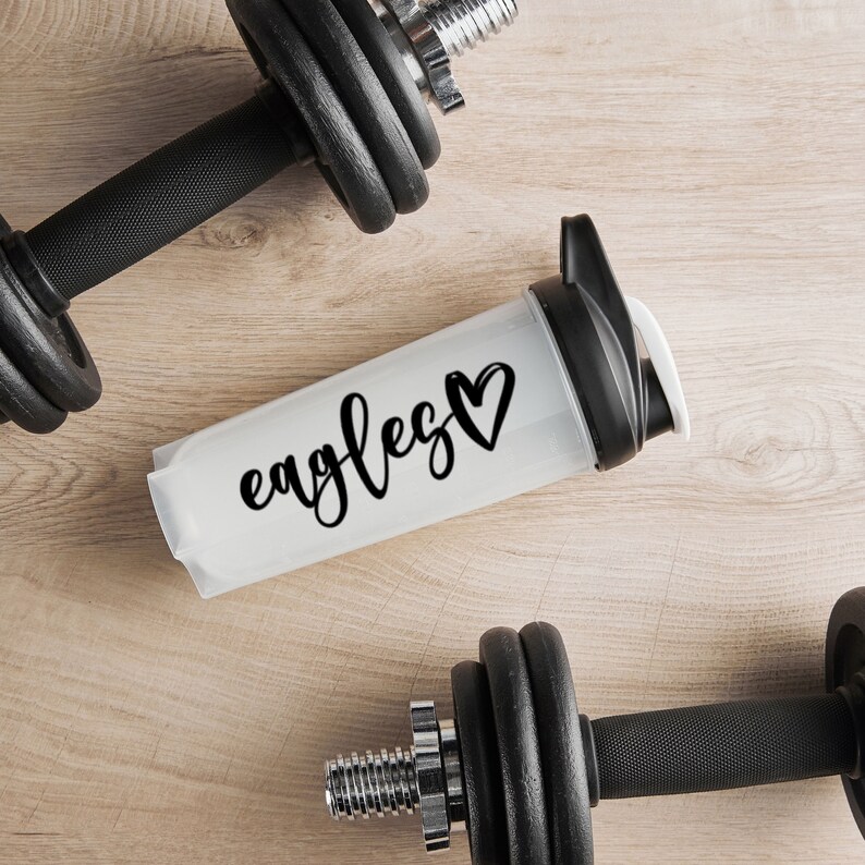 May include: White water bottle with a black heart and the text "eagles" in black script. Two black dumbbells are on either side of the bottle.