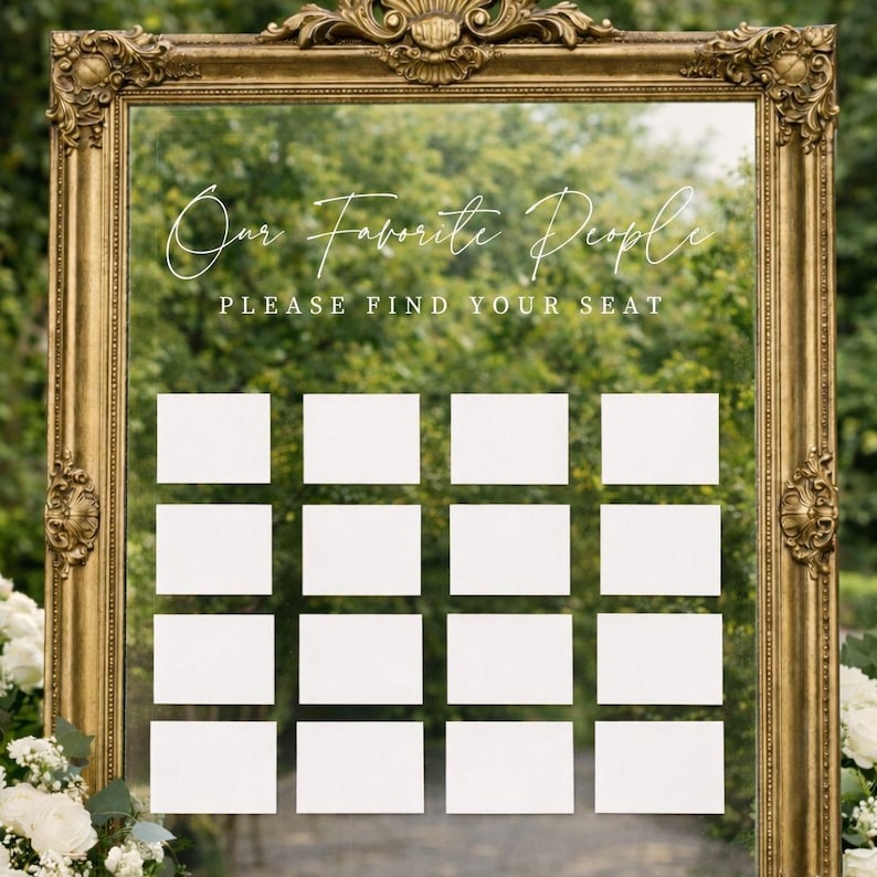 Op de afbeelding: Een grote, sierlijke goudkleurige vintage lijst rondom een heldere glazen spiegel. De spiegel bevat de witte tekst "Our Favorite People" in script en "PLEASE FIND YOUR SEAT" in blokletters, met zestien lege witte rechthoekige kaarten.