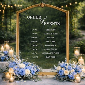 Pode incluir: Um grande espelho com moldura dourada arqueada exibindo o texto ORDER of EVENTS com um cronograma das 16h00 &agrave;s 23h30. O espelho &eacute; decorado com dois grandes arranjos florais de rosas azuis e brancas e folhagens, com pequenas velas.