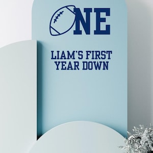 First Year Down Football Theme Birthday Decal Custom Name Football First Birthday Backdrop Decal Arch Sign for 1st Year Down Birthday Theme

Celebrate your little one’s milestone with this First Year Down football theme birthday decal designed for backdrops arches and welcome signs. Featuring your child’s name this custom vinyl decal is the perfect touch for a sports-themed first birthday party making your décor standout.