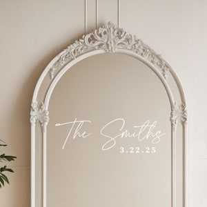 May include: A white ornate archway mirror with the text "The Smiths 3.22.25" written on the glass.