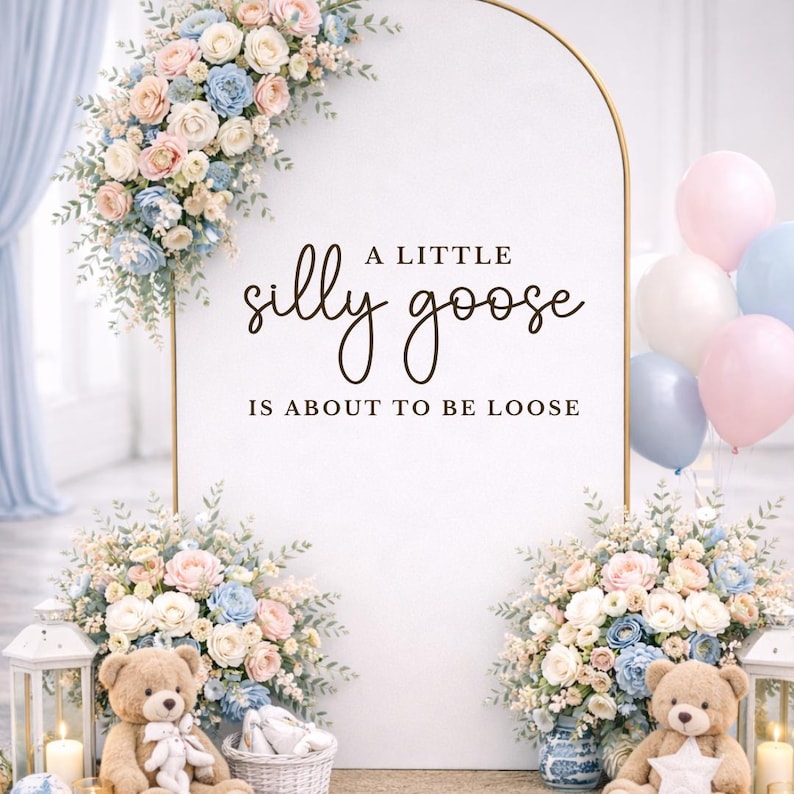 Op de afbeelding: Een witte achtergrond met de tekst "A LITTLE silly goose IS ABOUT TO BE LOOSE" is versierd met pastelkleurige bloemstukken, ballonnen, teddyberen en lantaarns. Een gouden boog omlijst de tekst.