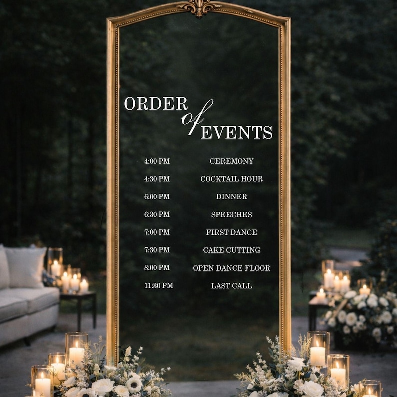 Pode incluir: Um espelho retangular alto com uma moldura dourada ornamentada, apresentando texto em branco que diz ORDER of EVENTS seguido por um cronograma das 16:00 CEREMONY &agrave;s 23:30 LAST CALL. O espelho &eacute; decorado com arranjos florais brancos na base.