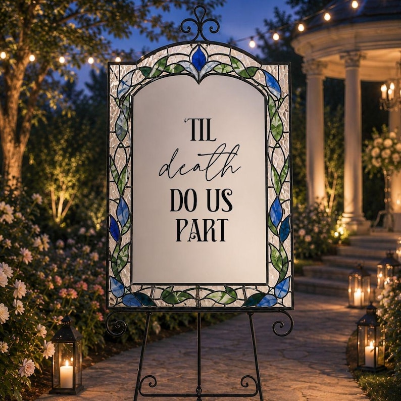 May include: A rectangular sign with a white center panel featuring the black text 'TIL death DO US PART'. The sign is framed by a decorative border of blue and green stained glass pieces in a floral pattern, supported by a black metal stand.