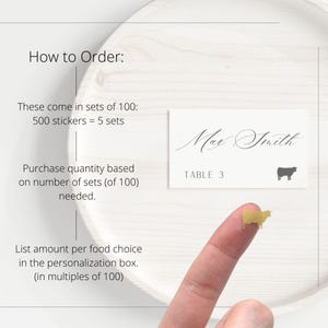 May include: A rectangular white place card featuring the name Max Smith in black script, the text TABLE 3, and a small black cow silhouette. A tiny gold cow sticker is shown separately. Text instructions explain ordering in sets of 100 stickers.