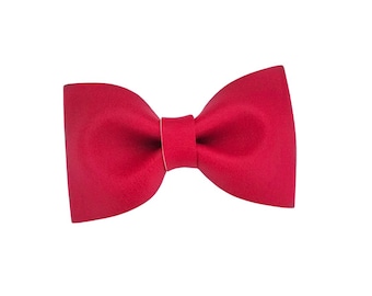 May include: A vibrant red bow tie, a classic accessory. The bow tie is a solid color, with a smooth texture and a symmetrical design. The bow tie is a formal wear accessory.