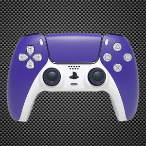 Puede incluir: Un mando inalámbrico PlayStation 5 DualSense de color morado y blanco. El mando tiene una placa frontal morada y botones y mangos blancos.