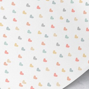May include: A white background with a repeating pattern of pastel colored hearts. The hearts are in shades of pink, blue, yellow, and gray.