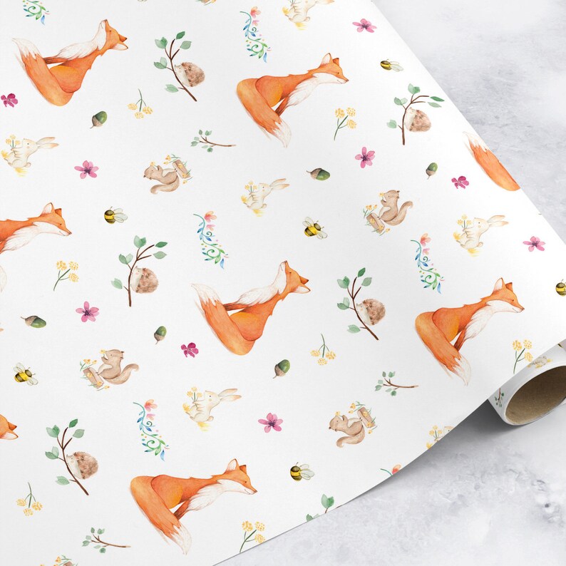 May include: White wrapping paper with a repeating pattern of orange foxes, squirrels, bunnies, bees, acorns, and flowers. The paper is rolled up and ready to be used.