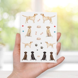 May include: A sheet of stickers featuring watercolor illustrations of Labrador Retrievers in both yellow and chocolate brown. The stickers include various dog-related icons such as bones, paw prints, and food bowls.