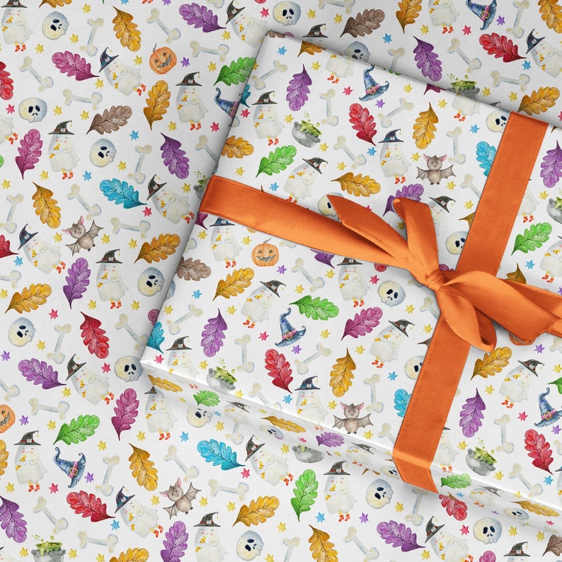 May include: White wrapping paper with a Halloween theme. The paper features a repeating pattern of bats, ghosts, pumpkins, bones, and leaves in shades of orange, green, purple, and blue. A bright orange ribbon is tied around the paper.