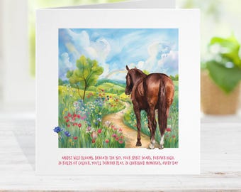 May include: A greeting card featuring a watercolor painting of a brown horse standing on a path in a colorful field. The scene includes a rainbow, a tree, and wildflowers. Text at the bottom reads: "Amidst wild blooms...in cherished memories, every day."