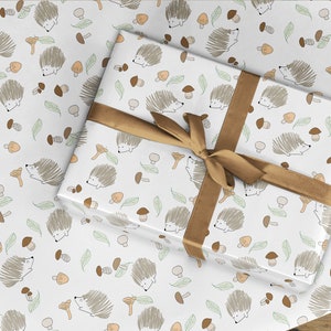 May include: White gift wrap with a repeating pattern of brown hedgehogs, green leaves, and brown mushrooms. The gift wrap is tied with a brown ribbon.