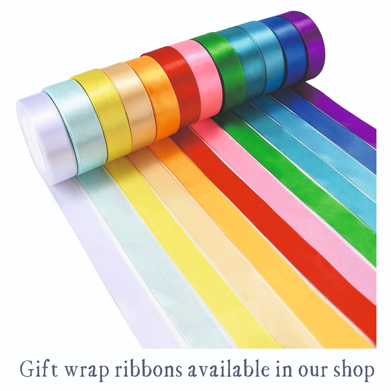 May include: A selection of colourful satin ribbon rolls, including purple, blue, green, yellow, orange, red, pink, light blue, and white. Gift wrap ribbons available in our shop.