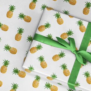 May include: White gift wrap with a green ribbon and a repeating pattern of yellow pineapples.